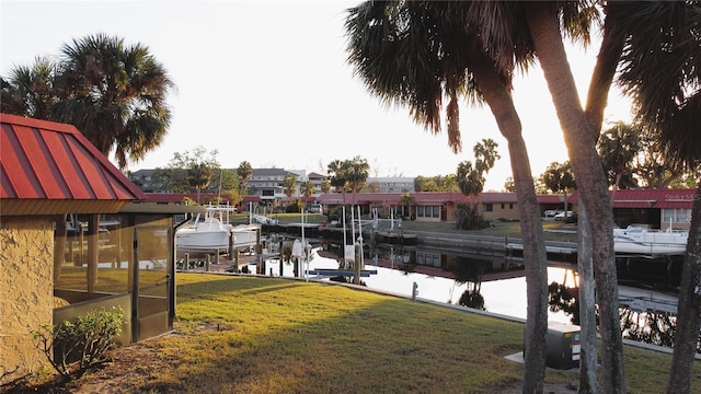 dock area with a yard and a water view