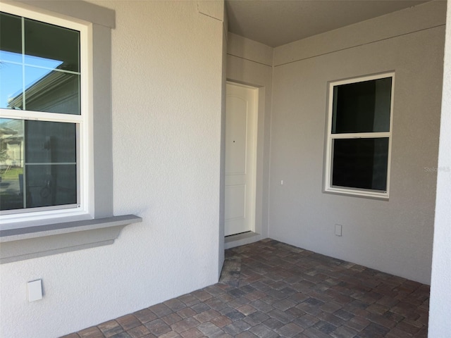 view of exterior entry with a patio