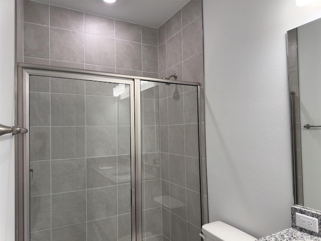 bathroom with vanity, toilet, and an enclosed shower