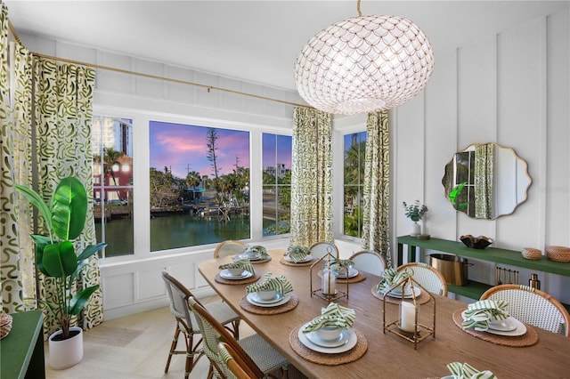 dining space featuring a notable chandelier and a water view