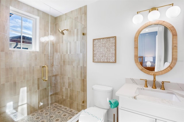 bathroom featuring toilet, a shower with door, and vanity