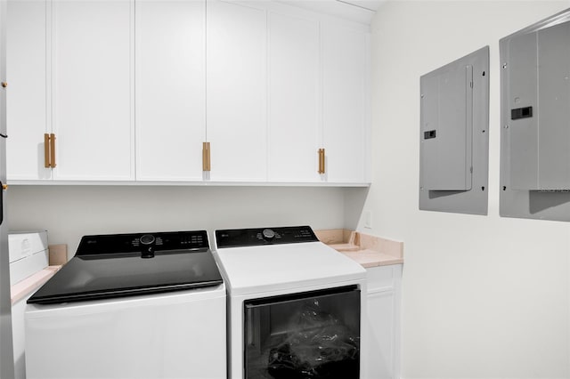 washroom featuring washing machine and clothes dryer, electric panel, and cabinets