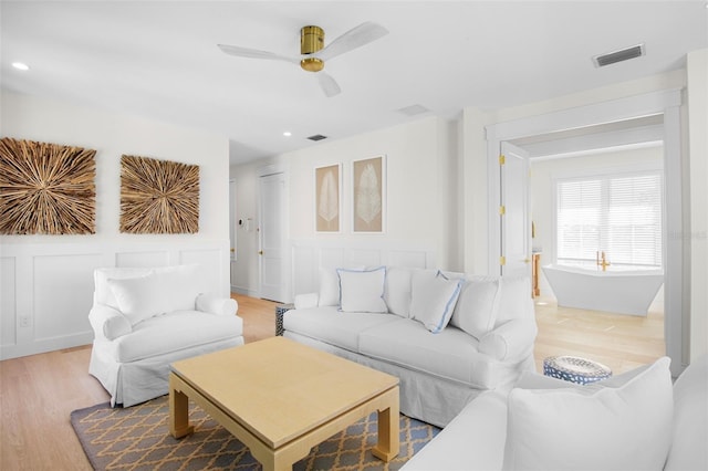 living room with ceiling fan and hardwood / wood-style floors