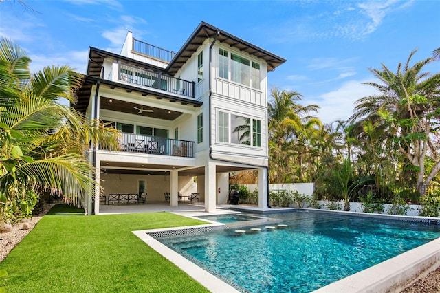 back of property featuring a patio, ceiling fan, a balcony, and a lawn