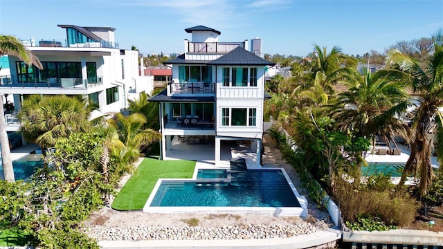 rear view of property with a balcony and a patio area