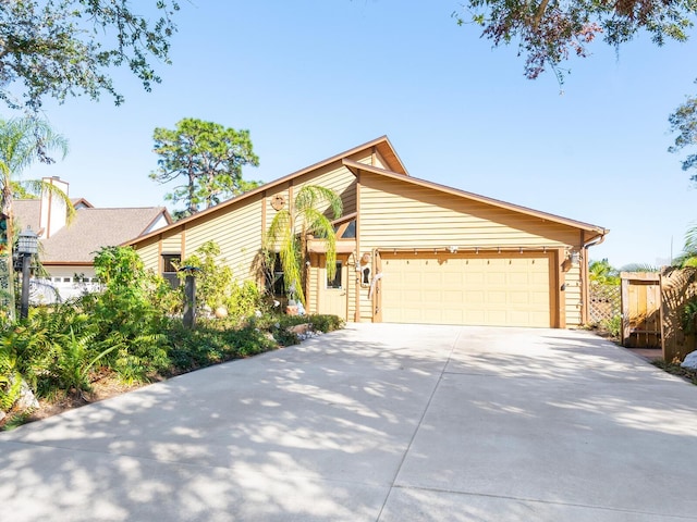 mid-century inspired home featuring driveway, an attached garage, and fence