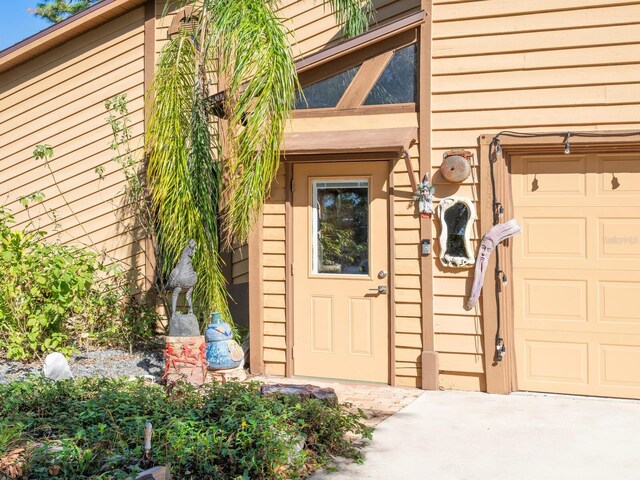 3888 Shady Brook Ln, Sarasota, FL 34243 - view of exterior entry with an attached garage and concrete driveway