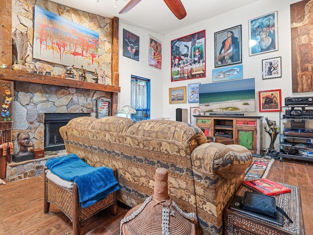 living room featuring a stone fireplace, ceiling fan, and hardwood / wood-style flooring