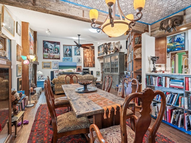 dining area featuring ceiling fan with notable chandelier, wood-type flooring, and a textured ceiling