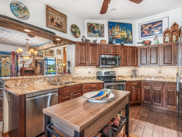 kitchen with kitchen peninsula, tasteful backsplash, stainless steel appliances, sink, and dark hardwood / wood-style floors