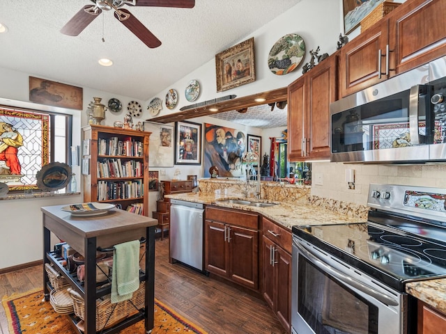 kitchen featuring a textured ceiling, stainless steel appliances, vaulted ceiling, dark wood-type flooring, and sink