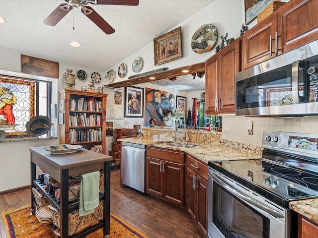3888 Shady Brook Ln, Sarasota, FL 34243 - kitchen featuring stainless steel appliances, a sink, a textured ceiling, dark wood-style floors, and vaulted ceiling