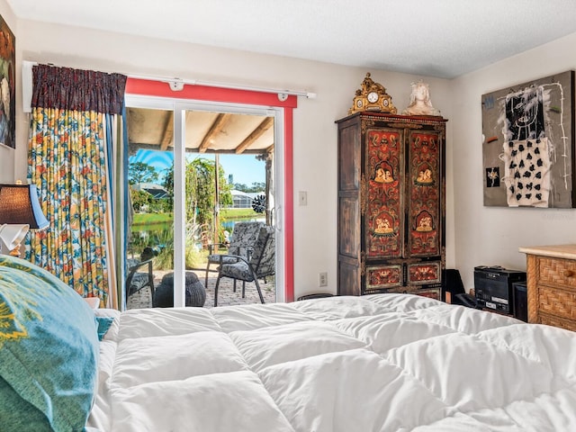 bedroom with a textured ceiling and access to outside