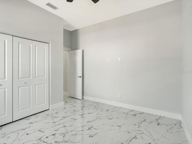 unfurnished bedroom featuring ceiling fan and a closet