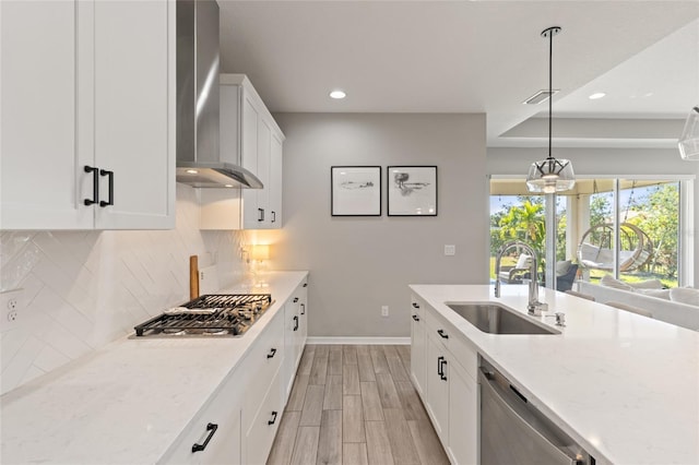 kitchen featuring light stone counters, sink, decorative light fixtures, and appliances with stainless steel finishes