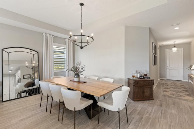 dining area featuring an inviting chandelier and light hardwood / wood-style flooring