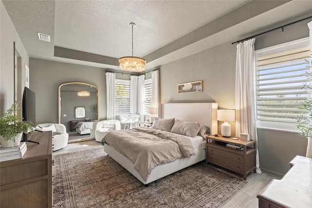 bedroom with a textured ceiling and an inviting chandelier