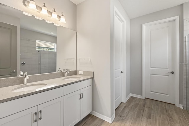 bathroom featuring hardwood / wood-style flooring, vanity, and a shower