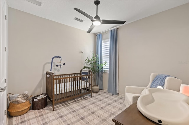 bedroom with ceiling fan and a crib