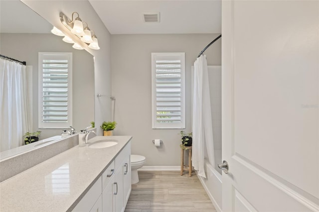 full bathroom featuring hardwood / wood-style floors, vanity, toilet, and shower / tub combo with curtain