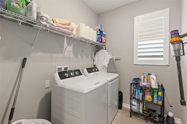 laundry room featuring washing machine and dryer and light wood-type flooring