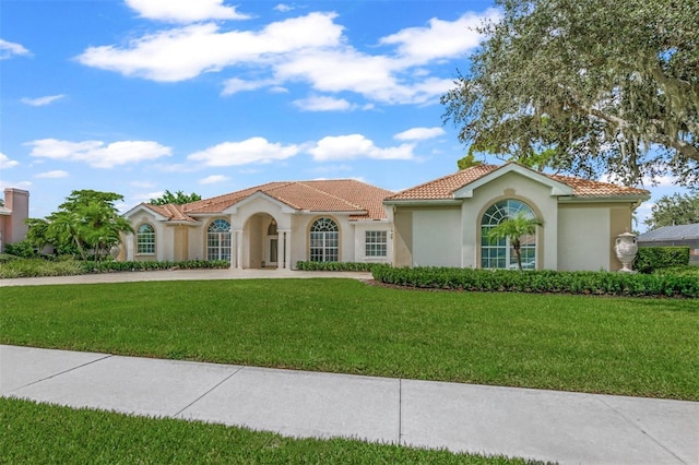 mediterranean / spanish home featuring a front yard