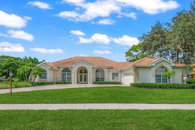 mediterranean / spanish home with a garage, a front yard, and french doors