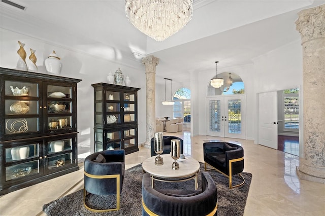 sitting room featuring ornate columns, french doors, a chandelier, and ornamental molding