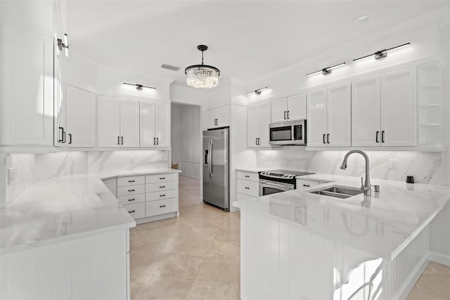 kitchen featuring kitchen peninsula, stainless steel appliances, sink, white cabinetry, and hanging light fixtures