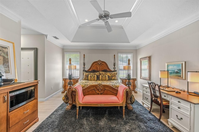 bedroom featuring a raised ceiling, ceiling fan, light hardwood / wood-style flooring, and ornamental molding