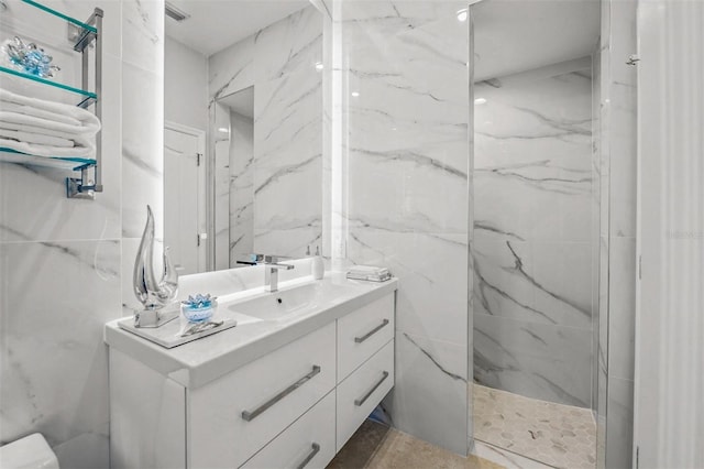 bathroom featuring a tile shower and vanity