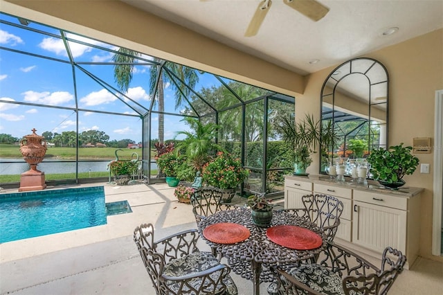 view of swimming pool with ceiling fan and a water view