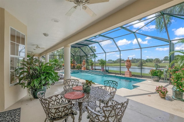 view of pool featuring pool water feature, a patio area, a lanai, and a water view