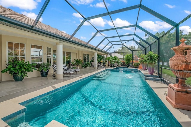 view of pool with a lanai, pool water feature, a patio, and a hot tub