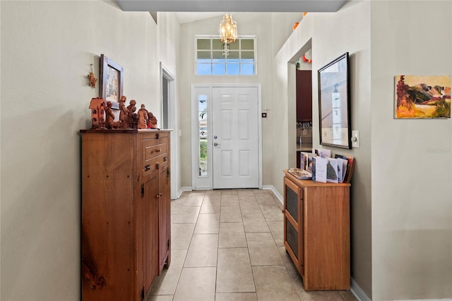 tiled entryway featuring a high ceiling and an inviting chandelier