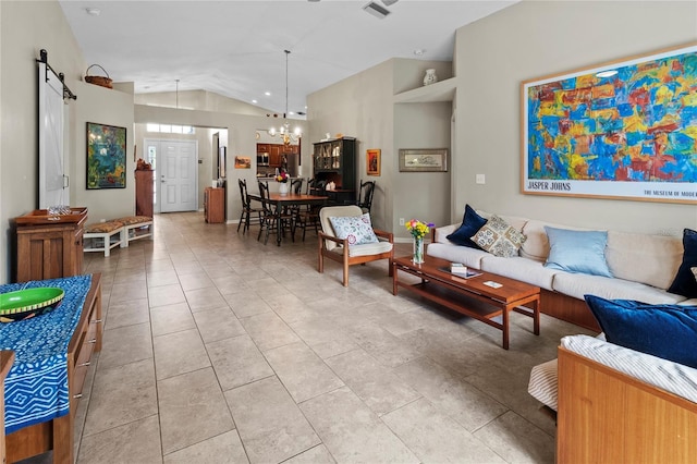 living room featuring a barn door, a chandelier, and lofted ceiling