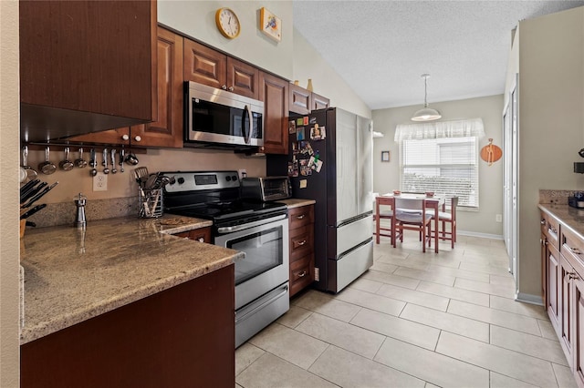 kitchen featuring appliances with stainless steel finishes, a textured ceiling, vaulted ceiling, light tile patterned floors, and pendant lighting