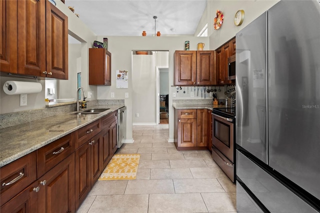 kitchen featuring sink, light stone countertops, light tile patterned floors, stainless steel appliances, and a chandelier