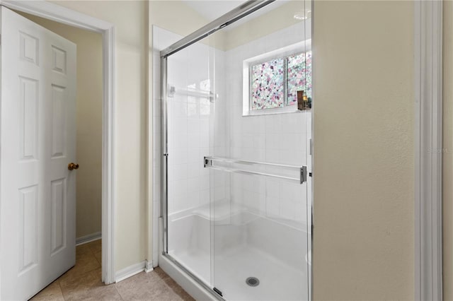 bathroom with tile patterned floors and a shower with shower door