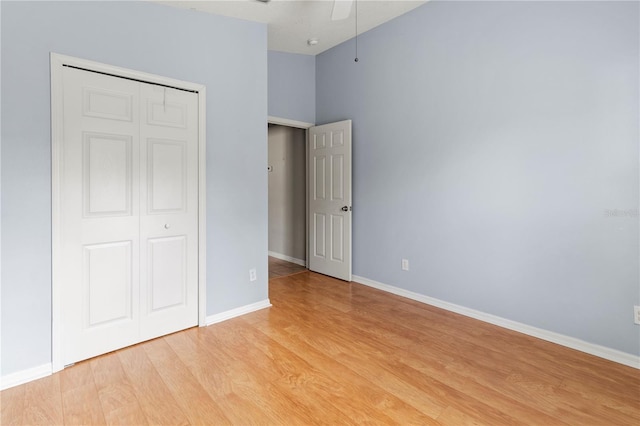 unfurnished bedroom featuring ceiling fan, a closet, and light hardwood / wood-style floors