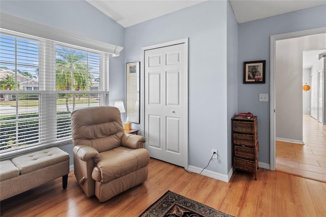 living area with light hardwood / wood-style flooring and vaulted ceiling