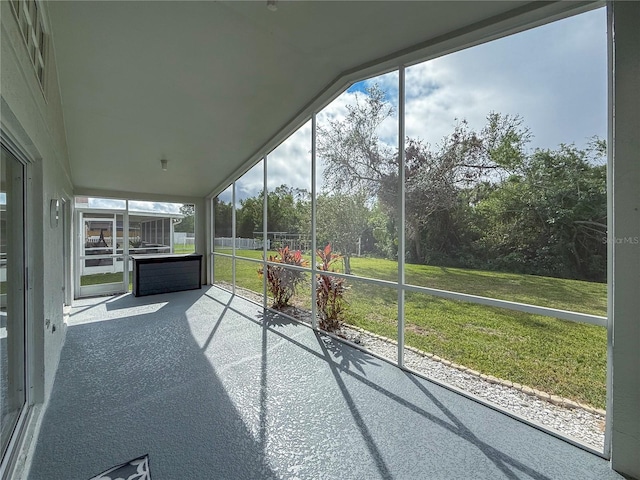 unfurnished sunroom featuring vaulted ceiling