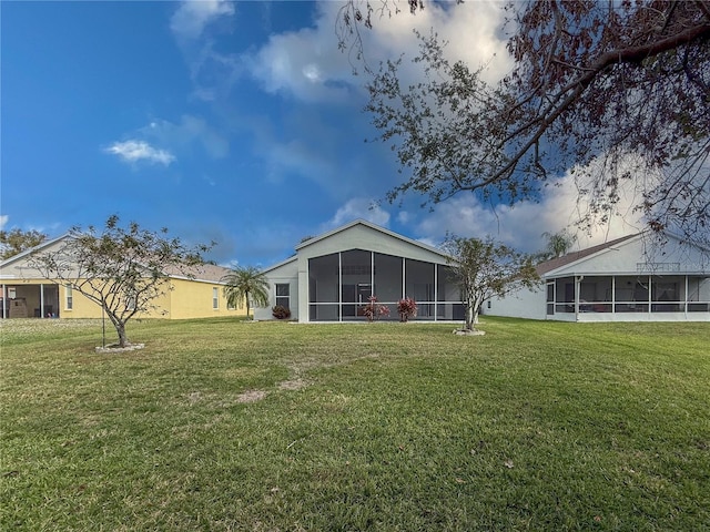 back of property featuring a lawn and a sunroom