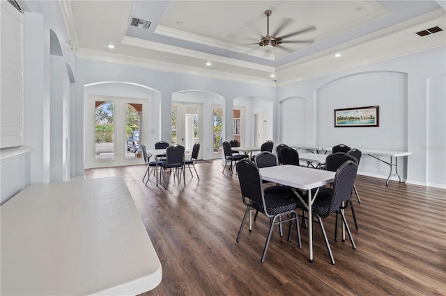 dining room featuring french doors, a raised ceiling, ceiling fan, dark wood-type flooring, and crown molding