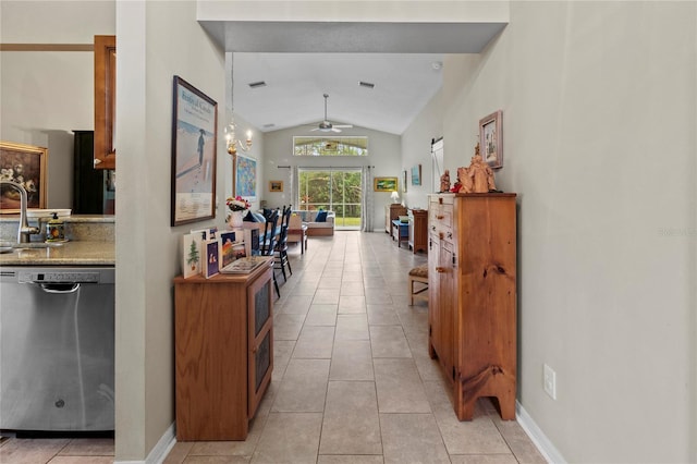 corridor with light tile patterned flooring, sink, and vaulted ceiling