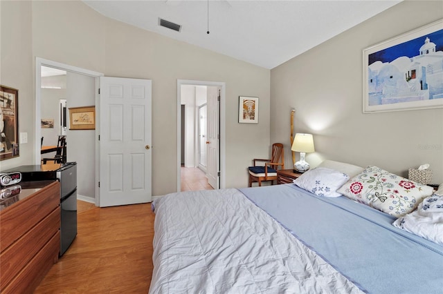 bedroom with light hardwood / wood-style floors and vaulted ceiling