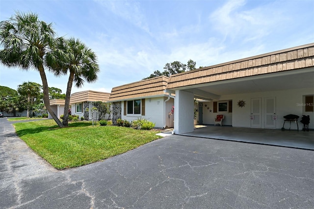 view of front of home with a front lawn and a carport