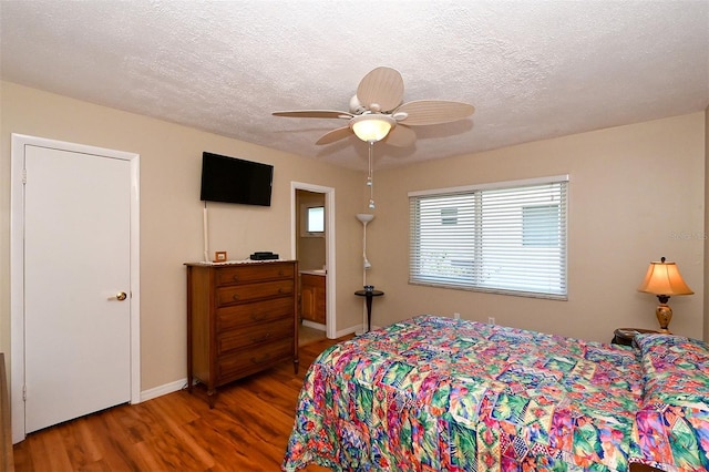 bedroom with ceiling fan, dark wood-type flooring, and a textured ceiling