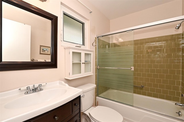 full bathroom featuring vanity, bath / shower combo with glass door, and toilet