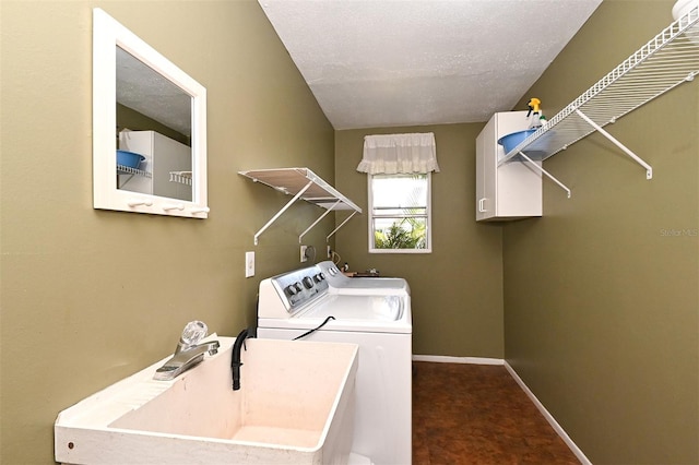 washroom featuring dark colored carpet, sink, a textured ceiling, and independent washer and dryer